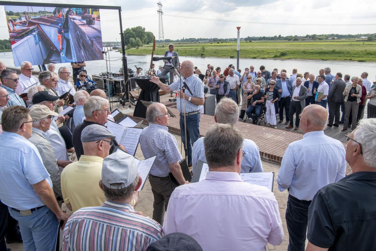 Het mannenkoor van Zangvereniging Vriendenkring uit Steyl zingt de aanwezigen toe tijdens de opening van de zelfsluitende waterkering in Steyl.