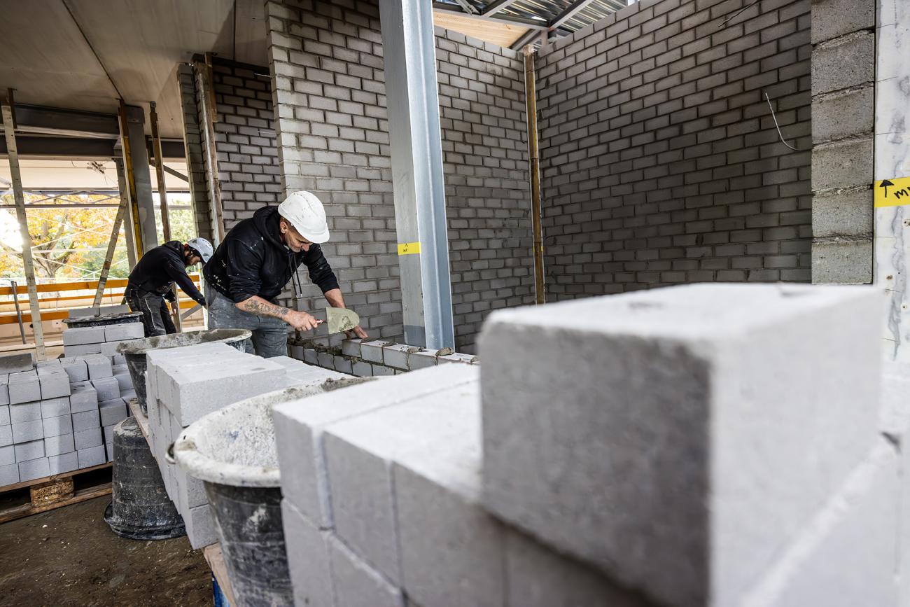 Foto van mannen die aan het metselen zijn