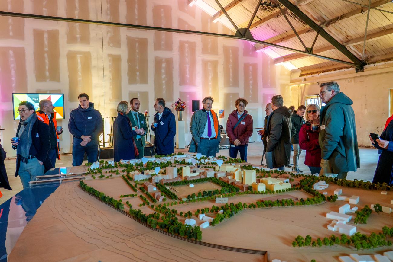 maquette van het kazernekwartier met pratende mensen op de achtergrond