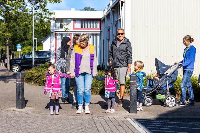 Ouders met kinderen op trottoir