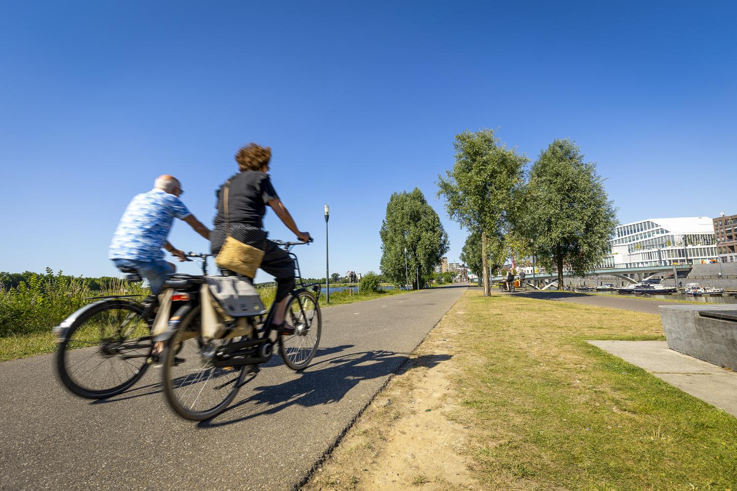 Fietsers op het fietspad langs de maas 