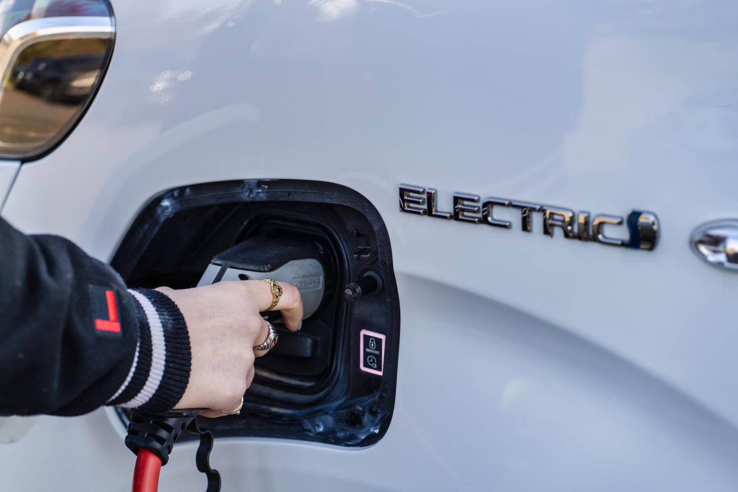 Een laadkabel wordt in de laadpoort van een elektrische auto gestoken