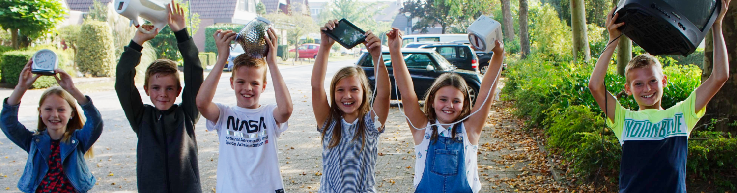 Kinderen met elektronisch afval in hun handen, zoals een waterkoker en een klok