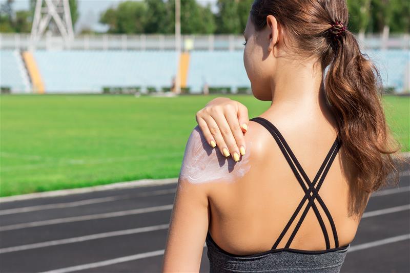 Persoon die zonnebrand opsmeert voor het sporten 