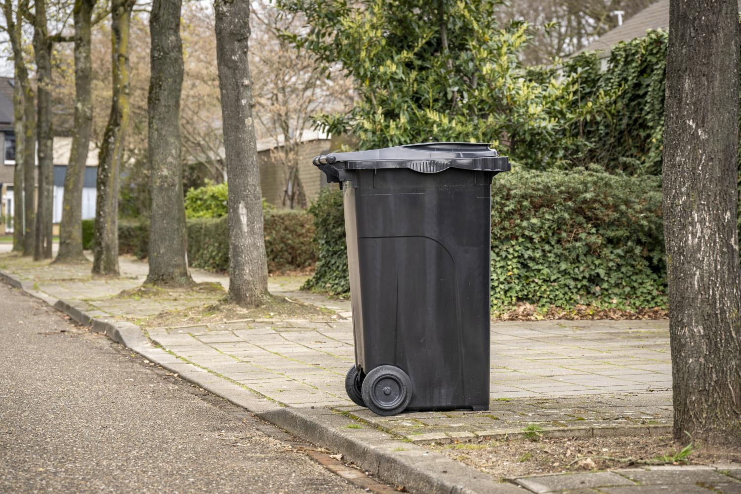 grijze container staat aan de straat