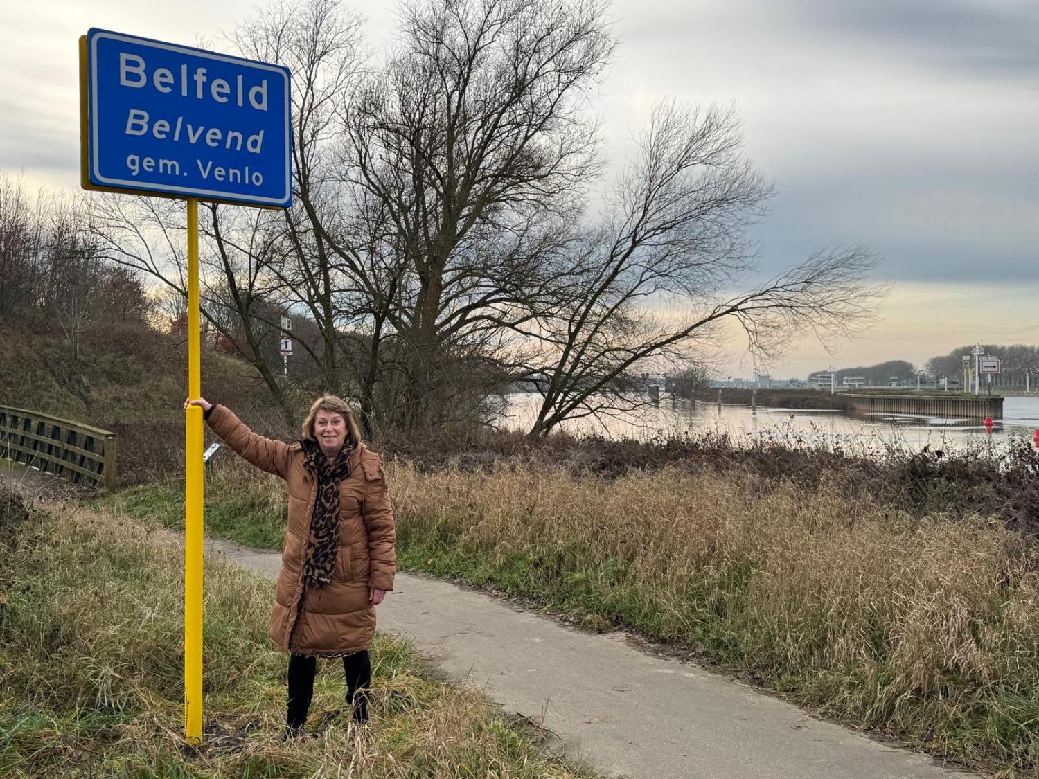 Wethouder Pollux bij plaatsnaambord van Belfeld