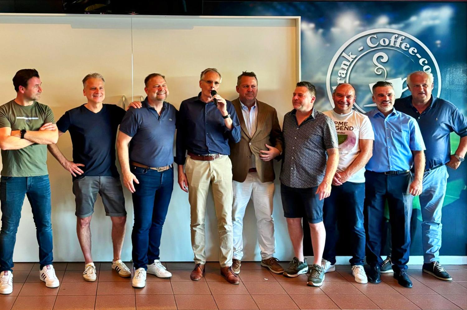 Groep mannen naast elkaar die blij zijn met de fusie in Tegelen