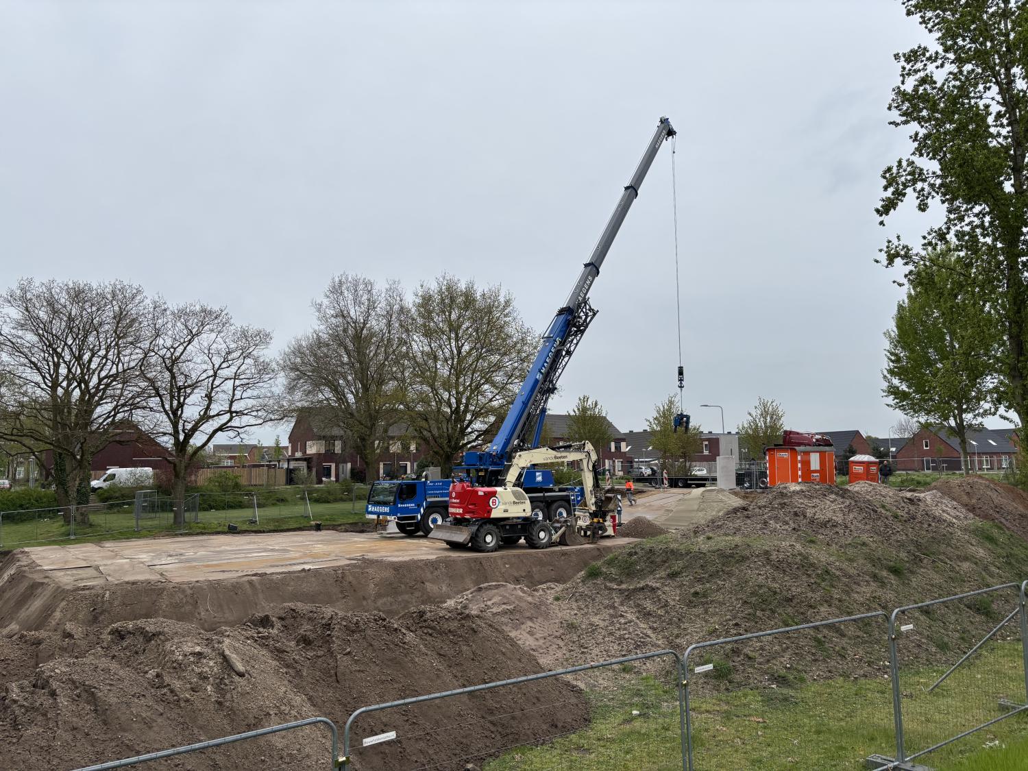 Een bouwplaats met een hijskraan en zand
