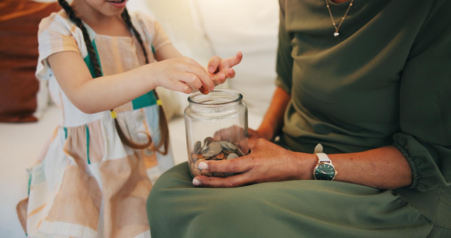 Kind doet geld in een pot 