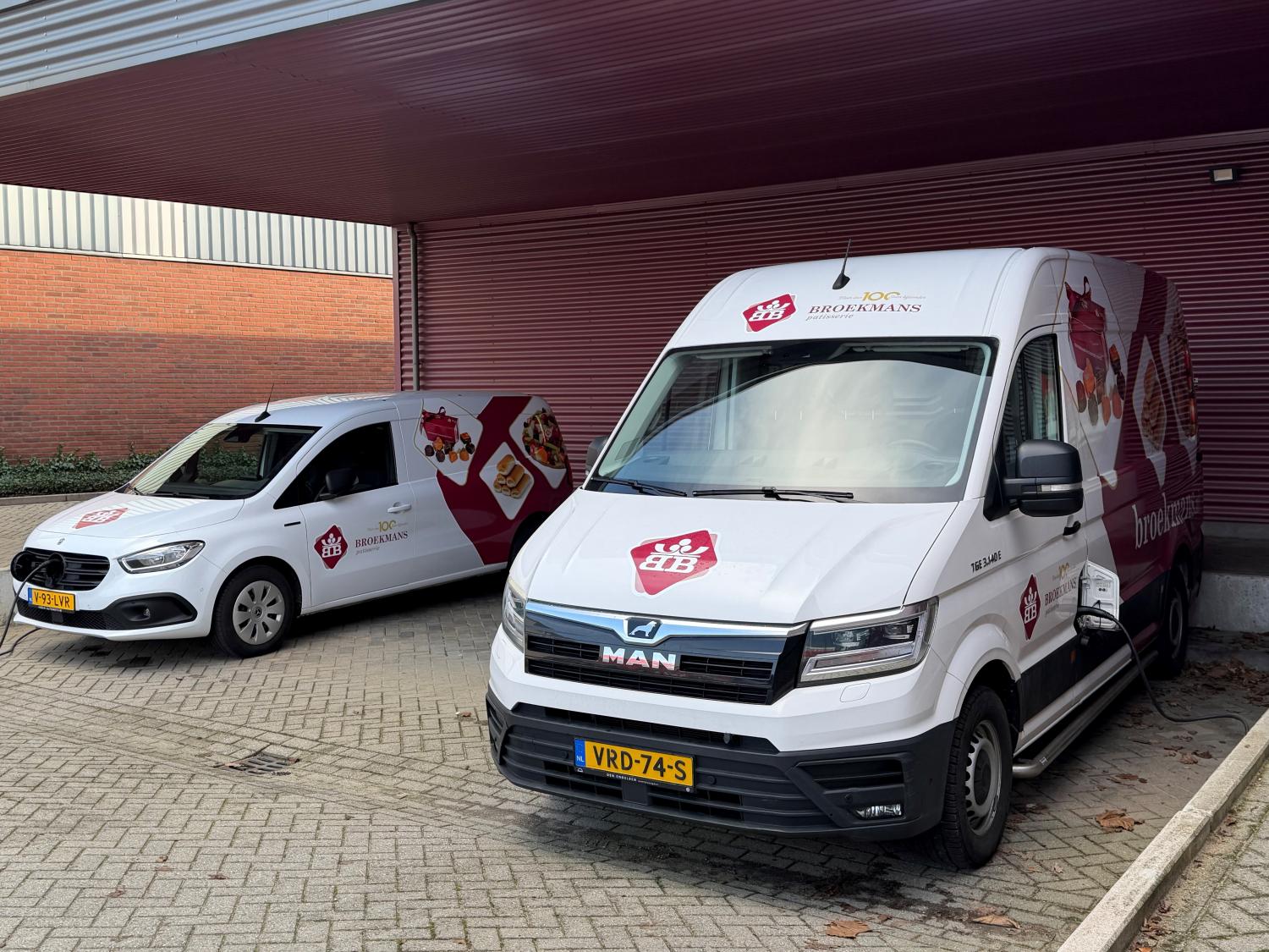 Twee elektrische bestelwagens van Broekmans Patisserie op een rij