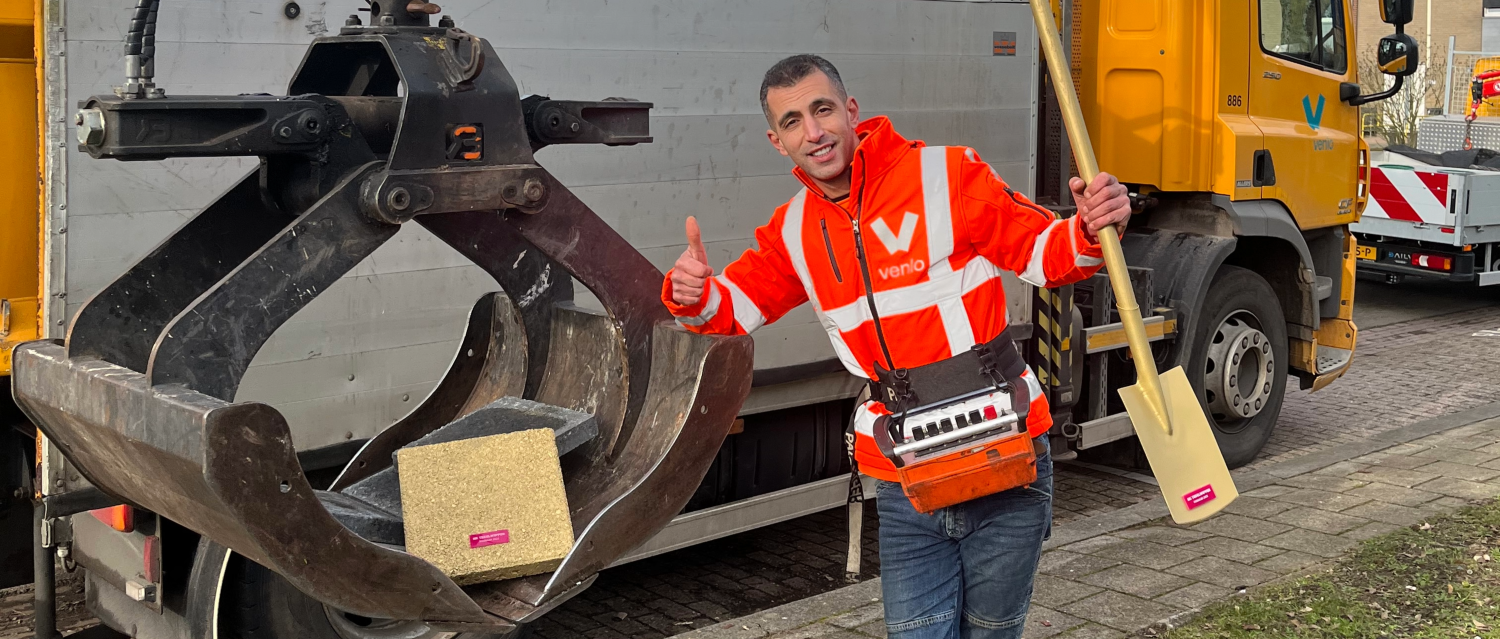 een medewerker van gemeente venlo die een gewipte tegel ophaalt met een vrachtwagen