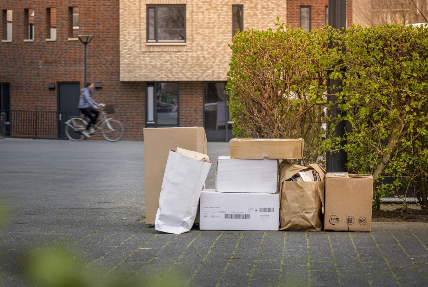 Oud papier in dozen bij lantaarnpaal