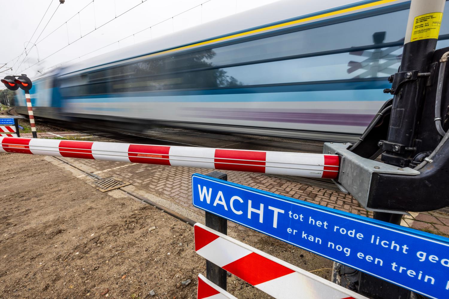 een trein die voorbij raast bij een spoorwegovergang