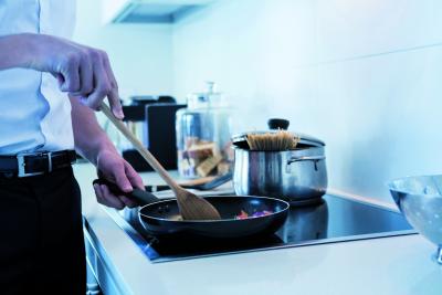 Een persoon die aan het koken is op een inductie kookplaat.