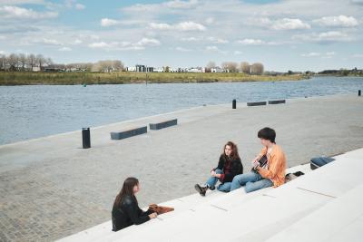 Drie jongeren die op de trappen zitten bij de Lage Loswal in Venlo. 