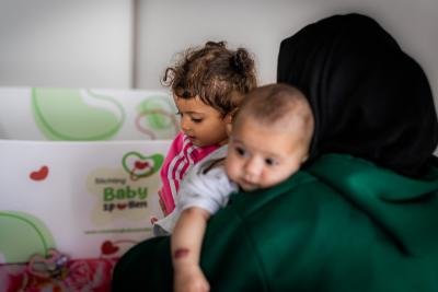 moeder met twee kinderen en de baby spullen box