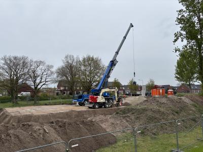 Een bouwplaats met een hijskraan en zand