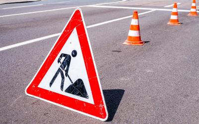 Bord wegwerkzaamheden en pionnen langs een weg