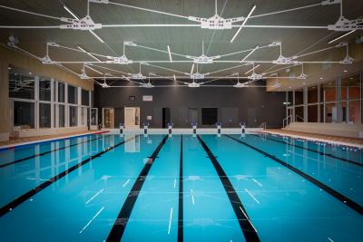Het wedstrijdbad van zwembad De Ploens met meerdere zwembanen, startblokken en een moderne overdekte zwemhal.
